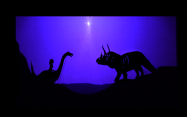 photographie extraite du spectacle le rêve d'Ambre, Ambre à l'époque des dinosaures, rencontre avec un tricératops