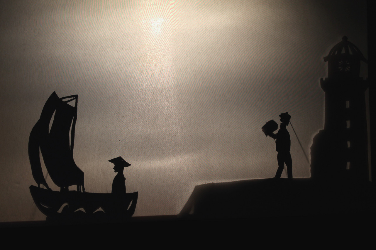 photographie extraite du spectacle Ginkgo et la lanterne magique, Ginkgo dans un port de pêcheurs en Europe