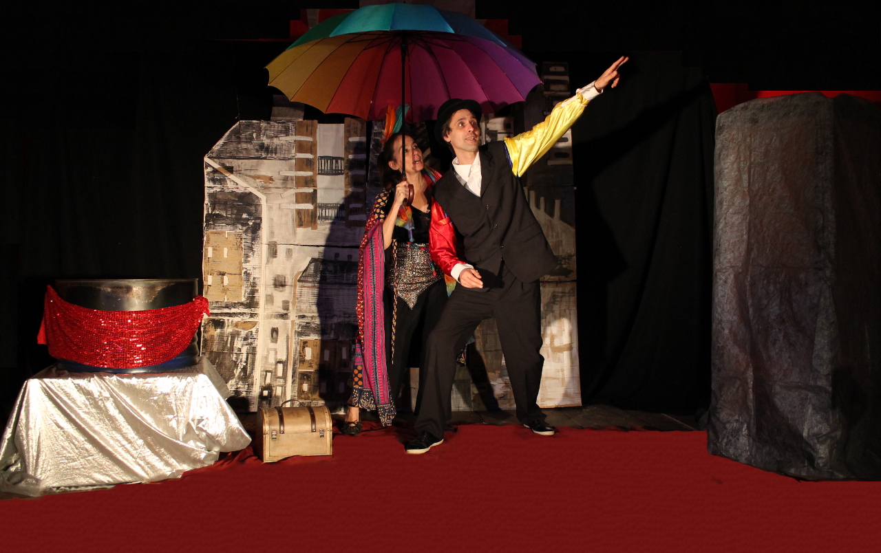 photographie extraite du spectacle jeune public les 7 flèches de l'arc-en-ciel, la magicienne des couleurs fait apparaître un arc-en-ciel pour monsieur Gris